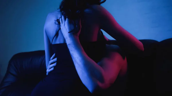 Abgeschnittene Ansicht eines muskulösen Mannes, der Liebe mit einer verführerischen Frau im blauen Kleid macht — Stockfoto