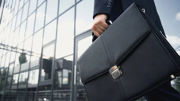 Cropped view of businessman holding leather briefcase — Stock Photo