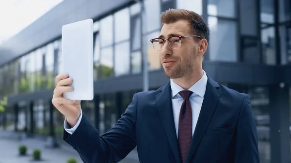 Uomo d'affari in bicchieri con tablet digitale all'esterno — Foto stock