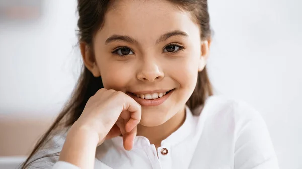 Lächelndes frühpubertierendes Mädchen blickt in die Kamera — Stockfoto