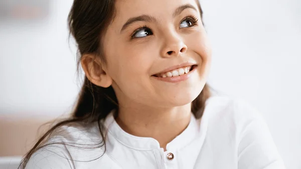 Smiling girl looking up at home — Stock Photo