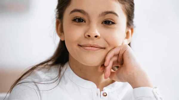 Lächelndes frühpubertierendes Mädchen blickt in die Kamera — Stockfoto