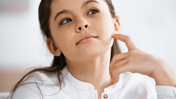 Pensive preteen girl looking away at home — Stock Photo