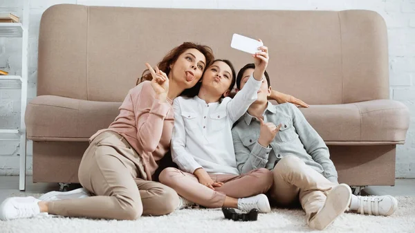 KYIV, UKRAINE -  APRIL 15, 2019: Family taking selfie near joystick on floor — Stock Photo