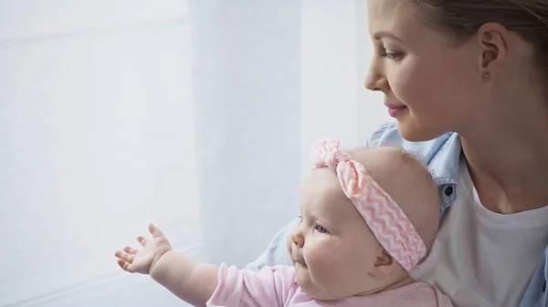 Glückliche Mutter hält Baby-Mädchen im Arm — Stockfoto