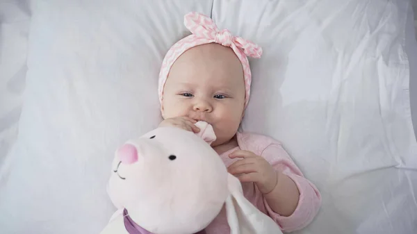 Top view of baby in headband with soft toy — Stock Photo