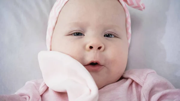 Vue de dessus du bébé avec jouet doux regardant la caméra — Photo de stock