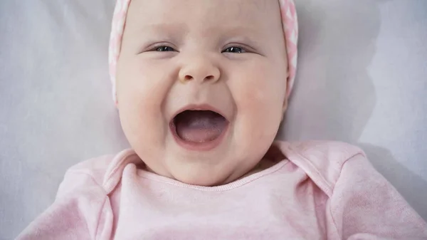Вид зверху на дивовижну немовля сміється в ліжку — стокове фото