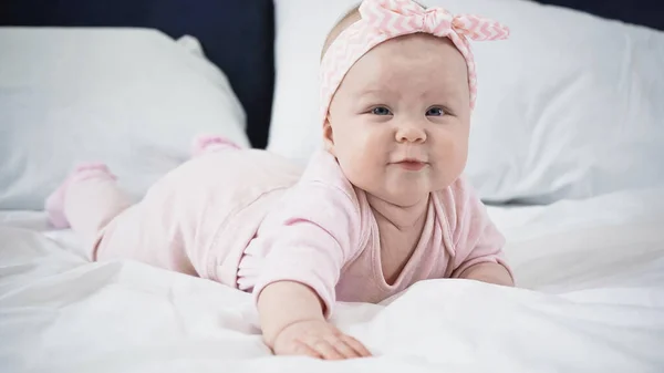 Neonata sdraiata sul letto a casa — Foto stock