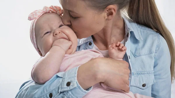 Мать целует младенца дочь сосать пальцы — стоковое фото