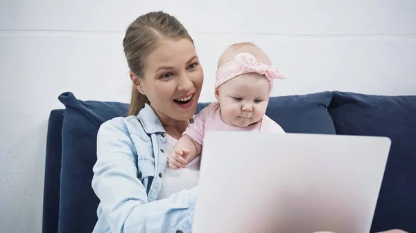 Madre sorprendida y niña mirando el ordenador portátil - foto de stock