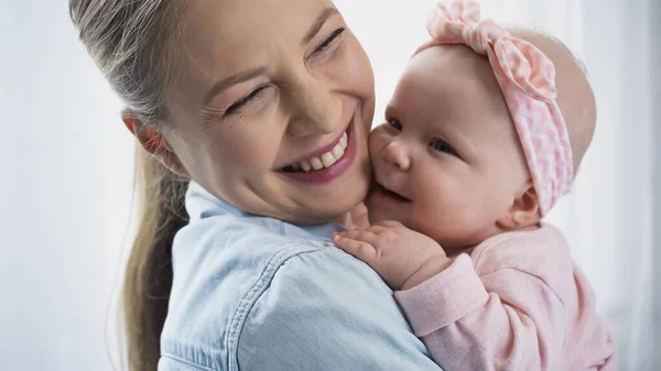 Cheerful mother holding in arms happy baby daughter — Stock Photo