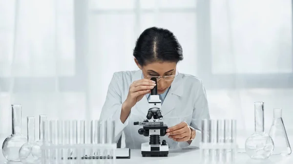 African american scientist in glasses looking through microscope in lab — Stock Photo