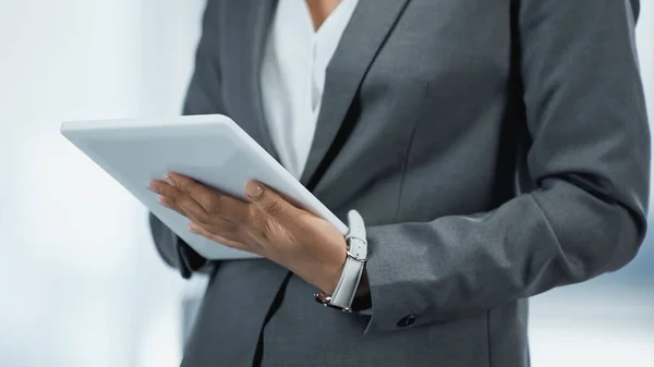 Cropped view of businesswoman in grey suit using digital tablet — Stock Photo