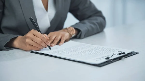 Vista recortada de la mujer de negocios firmar contrato - foto de stock