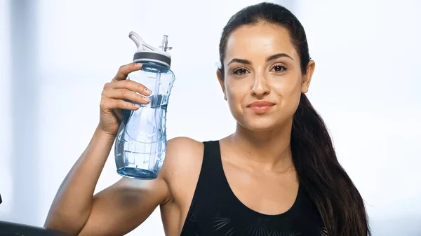 Young sportive woman holding sports bottle with water in gym — Stock Photo