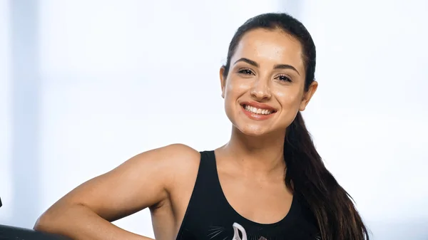 Щаслива і спортивна жінка посміхається в спортзалі — стокове фото