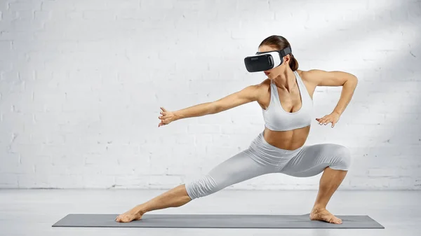 Donna scalza in cuffia vr in piedi su tappetino yoga — Foto stock