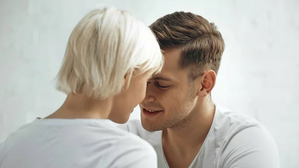 Feliz joven hombre y mujer rubia en casa - foto de stock