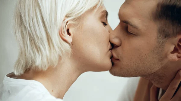 Close up de casal com os olhos fechados beijando em casa — Fotografia de Stock