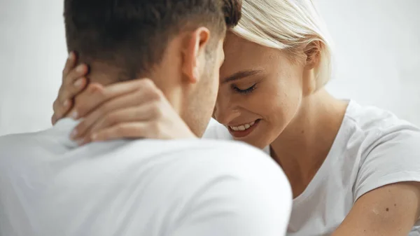 Mujer rubia feliz abrazando novio en primer plano borrosa - foto de stock