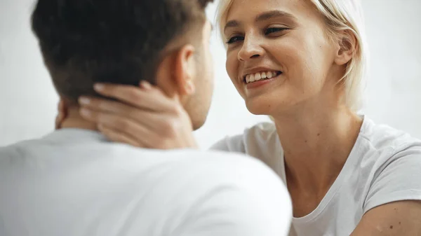 Cheerful blonde woman hugging boyfriend on blurred foreground — Stock Photo