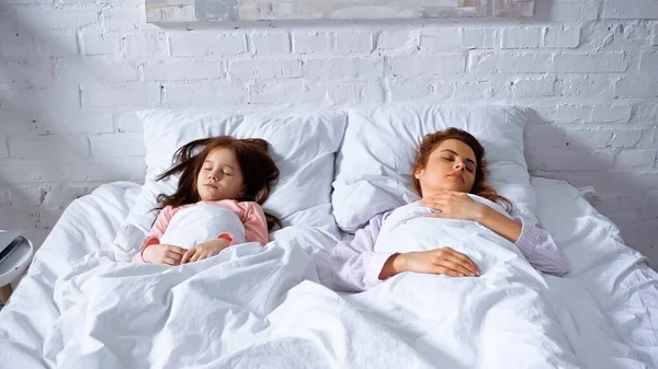 Mãe e filha dormindo na cama durante a manhã — Fotografia de Stock