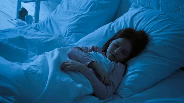 Bambino preadolescente che dorme in camera da letto di notte — Foto stock