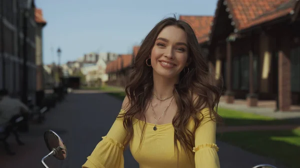 Felice giovane donna con i capelli ondulati sorridente fuori — Foto stock