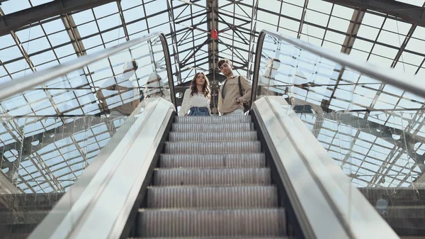 Vista di angolo basso della coppia vicino alla scala mobile nel centro commerciale — Foto stock