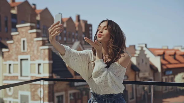 Felice giovane donna prendendo selfie e l'invio di bacio aereo — Foto stock