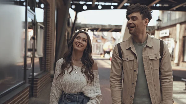 Веселый мужчина и женщина разговаривают во время прогулки по торговому центру — стоковое фото