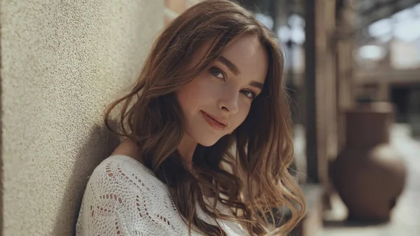 Hübsche junge Frau blickt in die Kamera in der Nähe des Gebäudes eines Einkaufszentrums — Stockfoto