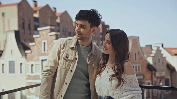 Feliz pareja de pie y sonriendo fuera - foto de stock