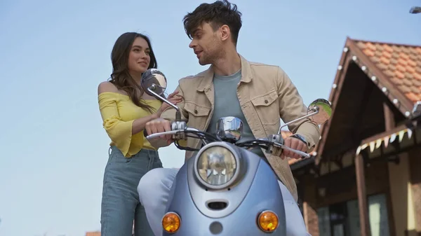 Man sitting on motorbike and looking at happy young woman — Photo de stock