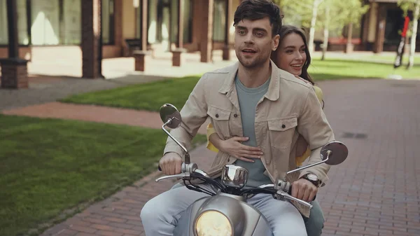 Cheerful couple riding motorcycle outside on street — Photo de stock