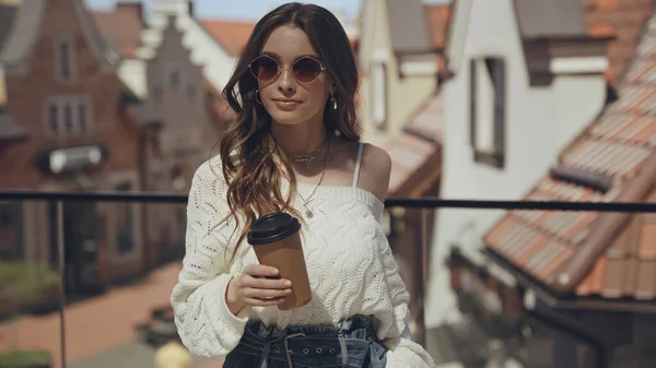 Jovem elegante em óculos de sol segurando café para sair — Fotografia de Stock