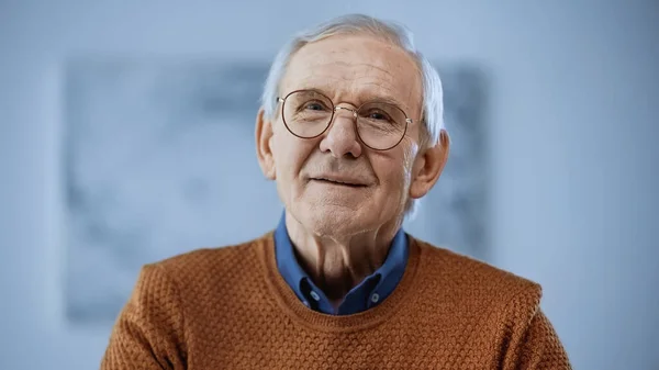 Porträt eines fröhlichen Seniors mit Brille auf grauem Hintergrund — Stockfoto