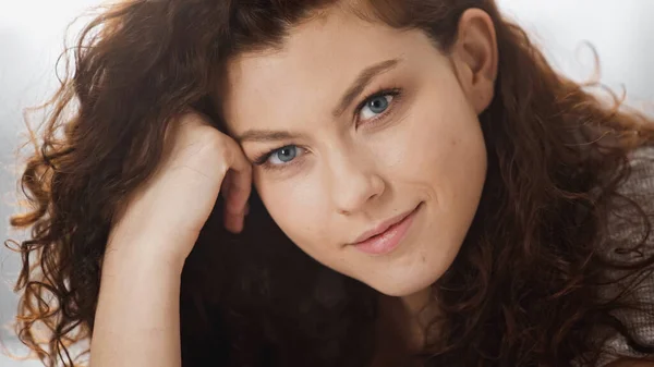 Portrait de femme heureuse et bouclée regardant la caméra — Photo de stock