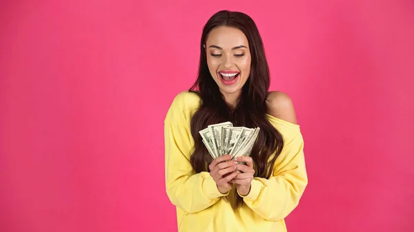 Excited young adult woman holding dollar banknotes in hands isolated on pink — Fotografia de Stock