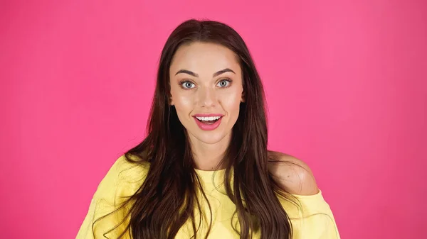 Positive young adult woman in yellow blouse looking at camera isolated on pink — Foto stock