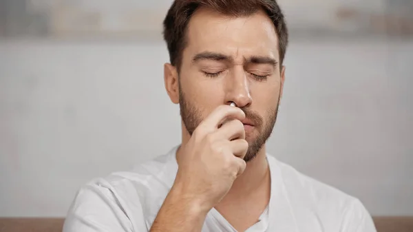 Allergic man using nasal spray at home — Stock Photo