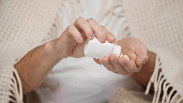 Cropped view of man holding bottle with pills - foto de stock