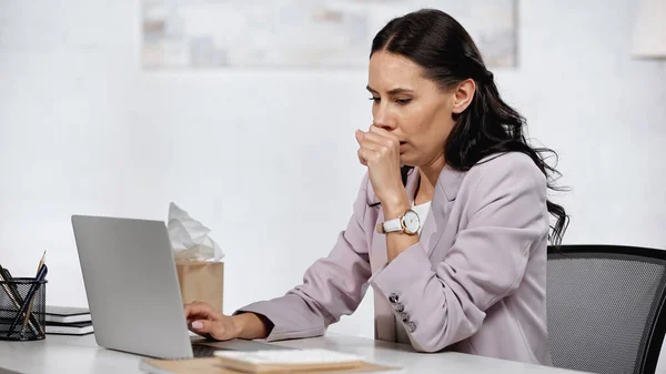 Allergische Geschäftsfrau liegt neben Laptop auf Schreibtisch — Stockfoto