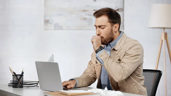 Allergiker Geschäftsmann liegt neben Laptop auf Schreibtisch — Stockfoto