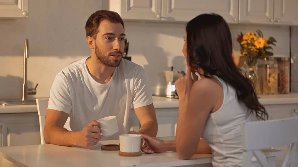 Bearded man holding cup and talking with blurred girlfriend — Foto stock