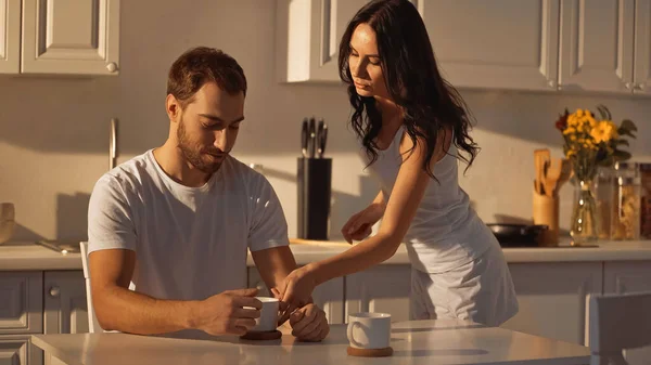 Brunette woman serving cup of coffee to boyfriend — Foto stock