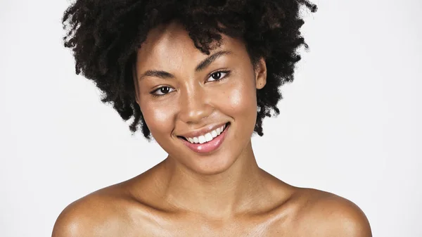 Junge afrikanisch-amerikanische Frau mit sauberer Haut und nackten Schultern, die isoliert auf grau lächelt — Stockfoto