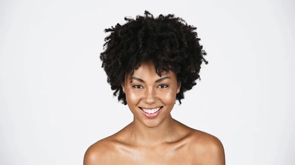 Jeune femme afro-américaine aux épaules nues souriant à la caméra isolée sur gris — Photo de stock