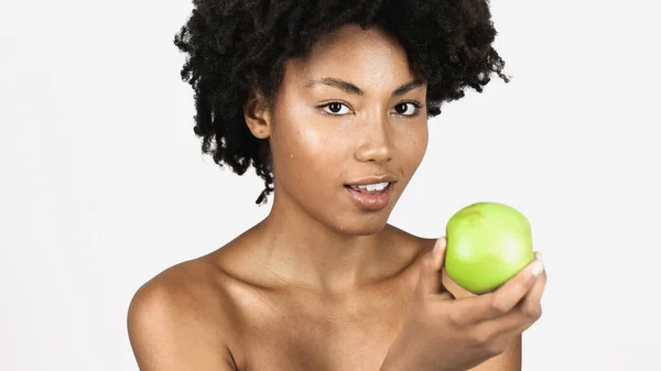 Bella donna afro-americana con viso pulito con mela verde isolata su grigio — Foto stock